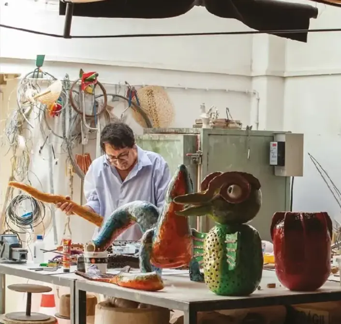Ceramic artist working among expressive glazed sculptures