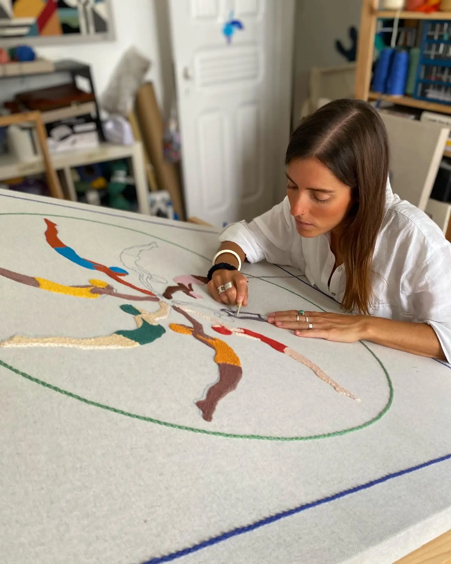 Artist building a miniature architectural piece at her workbench