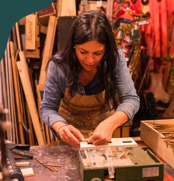 Textile artist hand-finishing a large work in her studio
