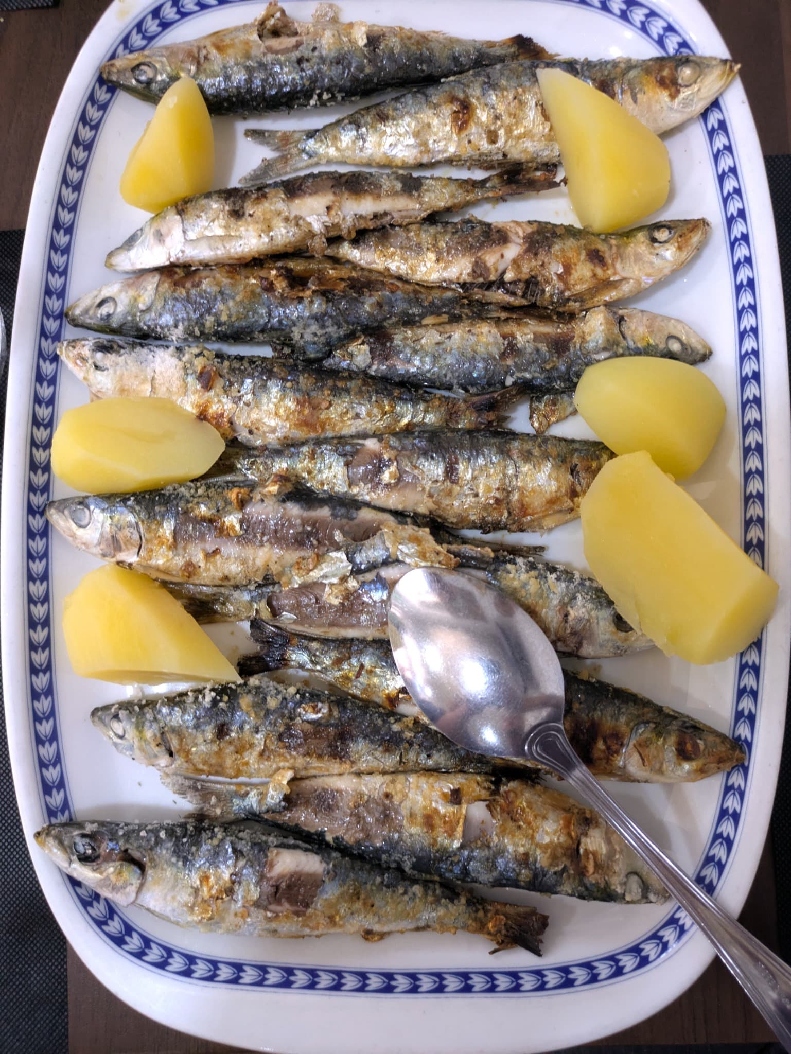 A platter of grilled Portuguese sardines with potatoes
