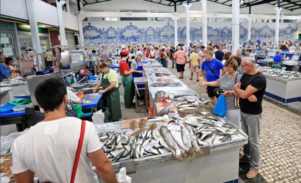 Fish stalls, shoppers and blue-and-white tiles inside Mercado do Livramento
