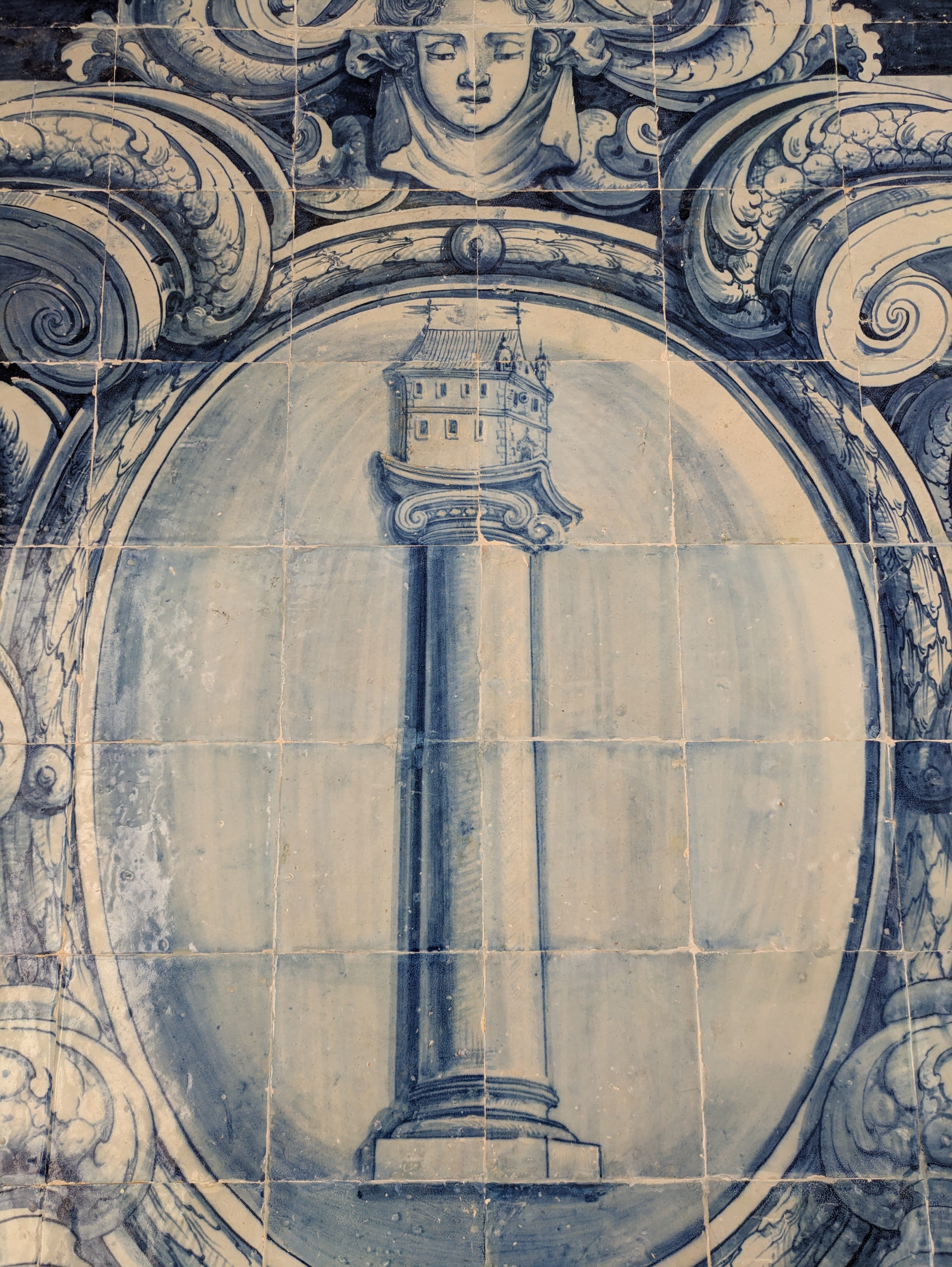 A pale blue Portuguese azulejo panel with an ornate arch and central tower