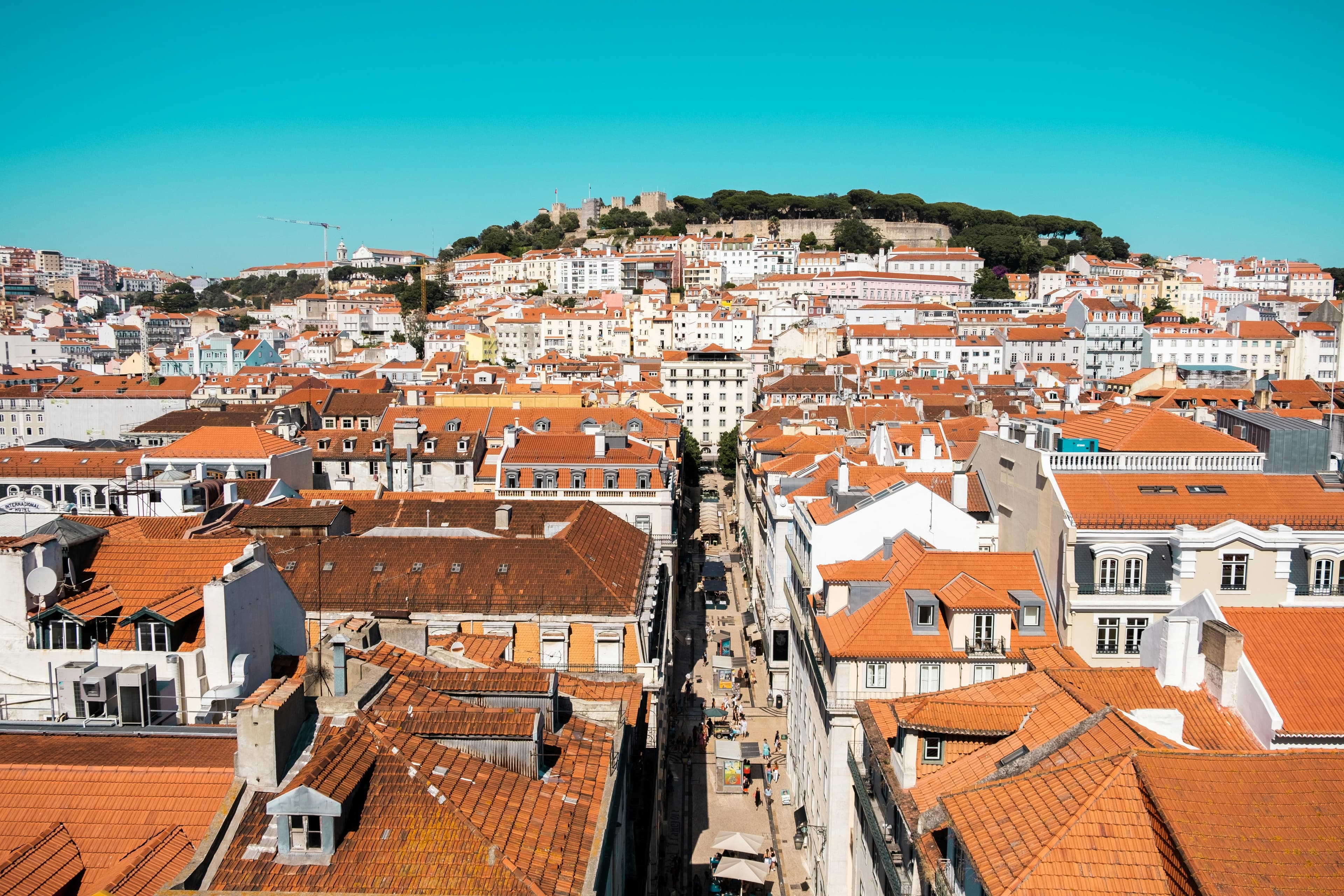 Lisbon’s historic rooftops and São Jorge Castle beneath a clear blue sky