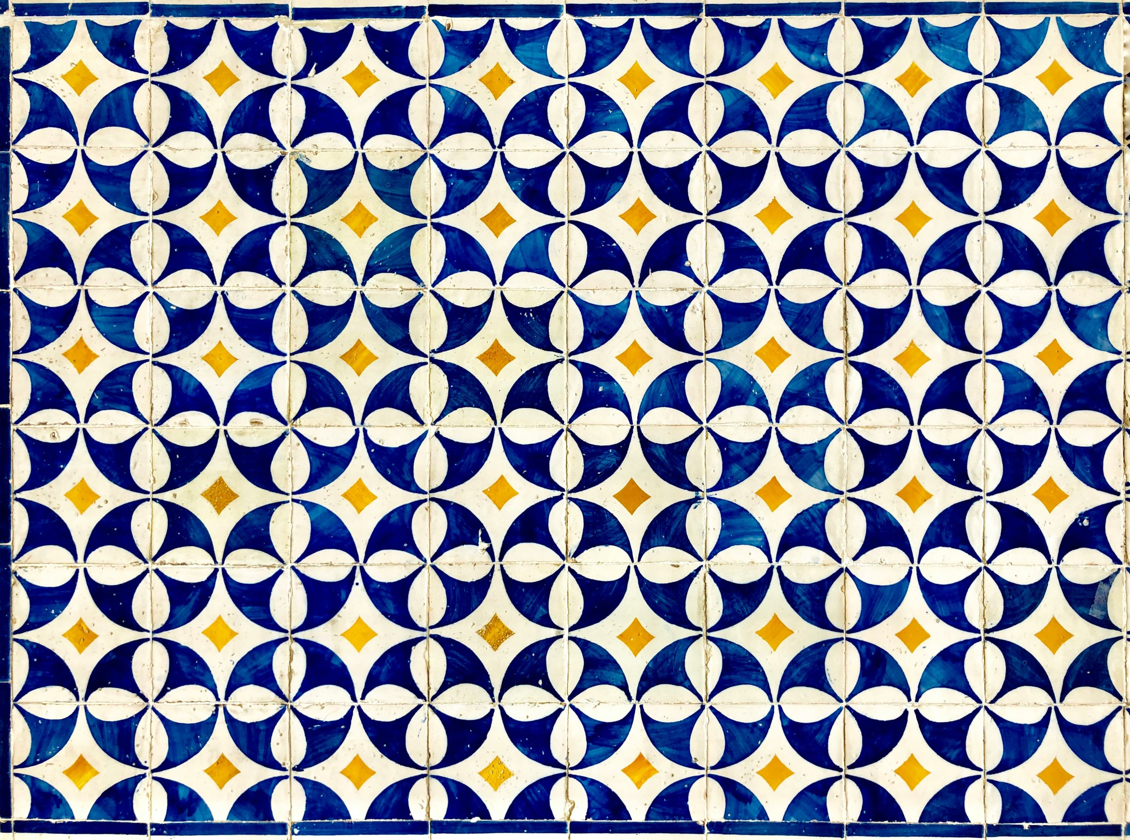 A repeating navy-and-white Portuguese tile pattern with gold diamond accents