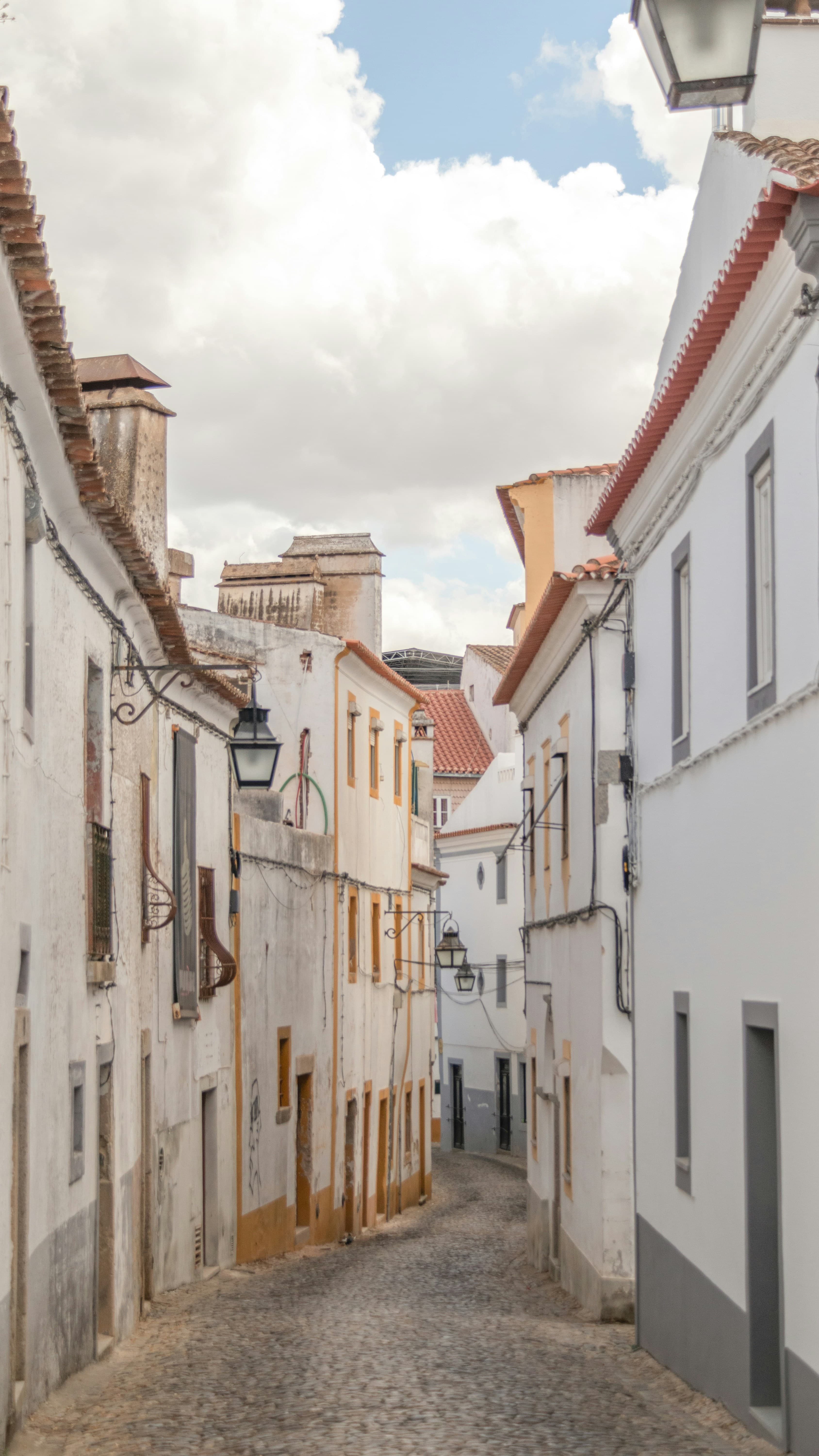 A narrow whitewashed historic street in Évora