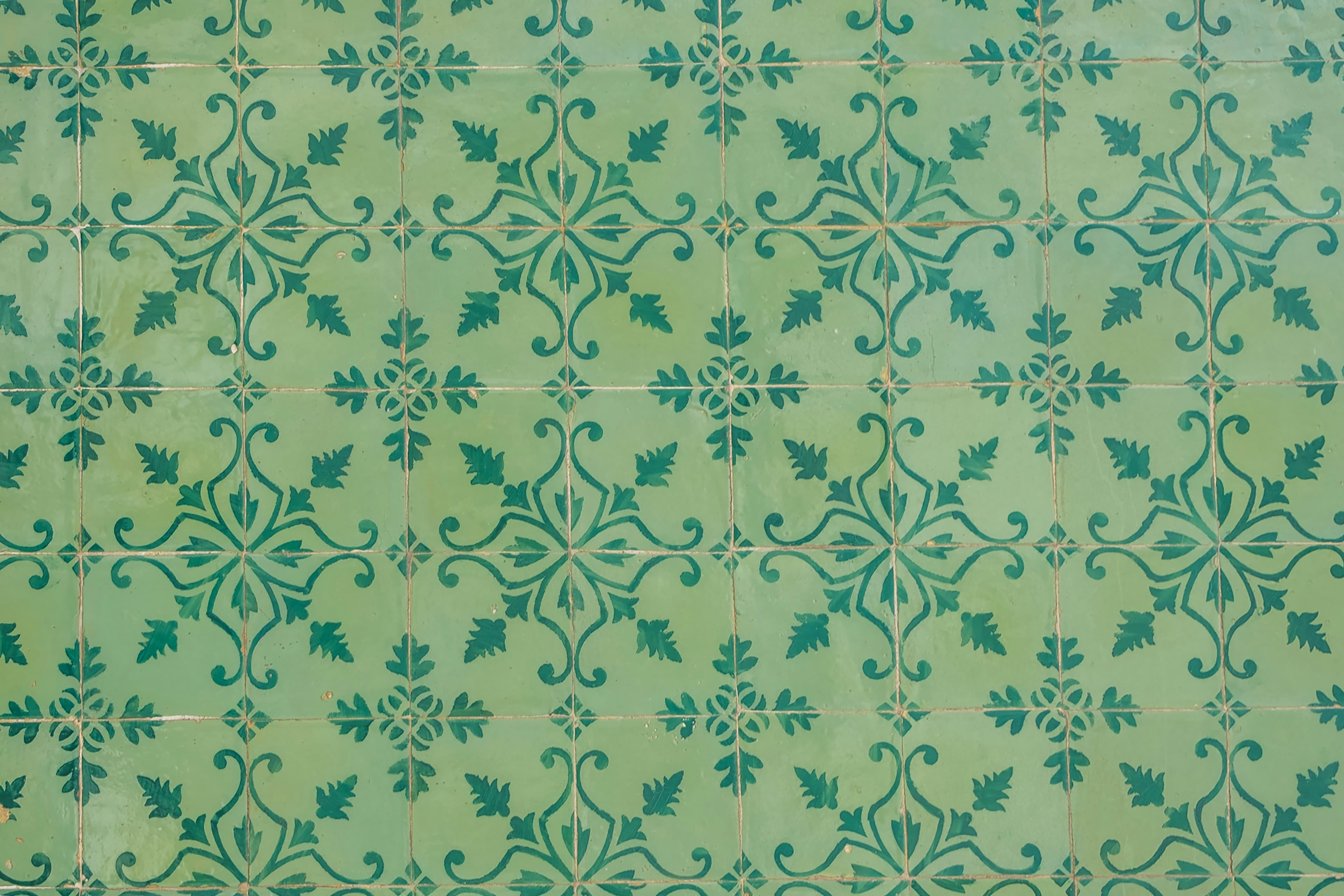 A repeating mint-green Portuguese tile pattern with botanical motifs